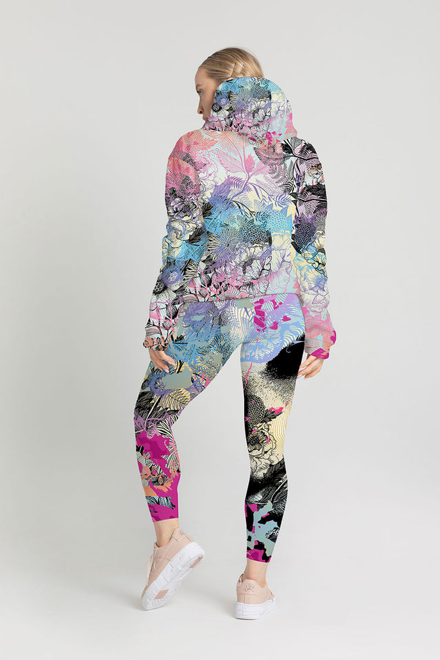 Female model is dressed in a bright pattern hoodie and jogger set.